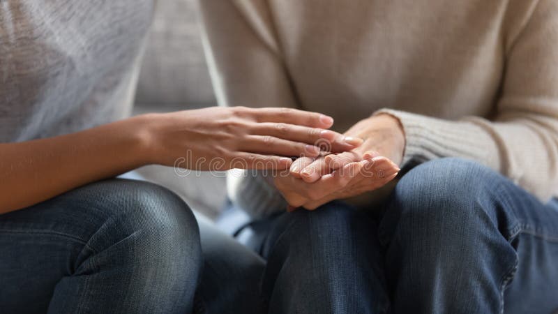 Close up image adult daughter touches hands of aged mother stock photography Close up image adult daughter touches hands of aged mother stock photography
