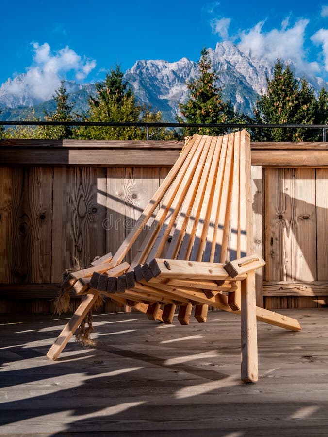 Image of wooden chair on balcony in alpine landscape