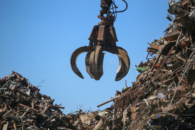 Close up industrial claw machine, move scrap metal in the landfill. royalty free stock photography