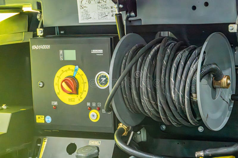 Close-up of industrial equipment with a large cable spool and electronic control panel The cable spool is tightly wound with dark stock image