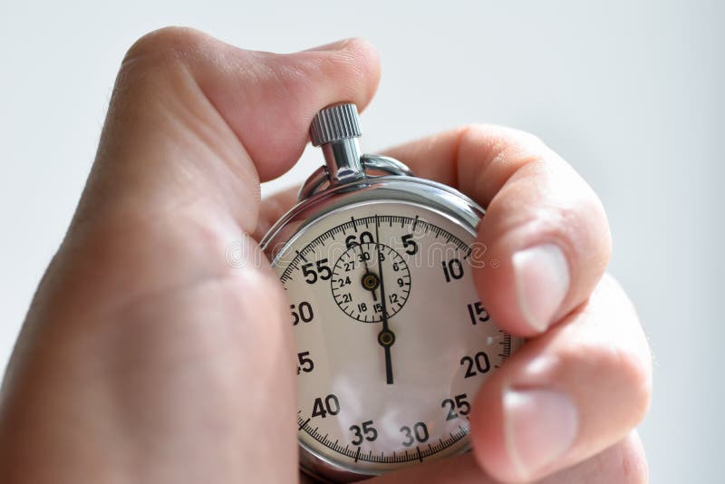 A close-up of an isolated hand presses the stopwatch start button in the sport, measurements, metrology