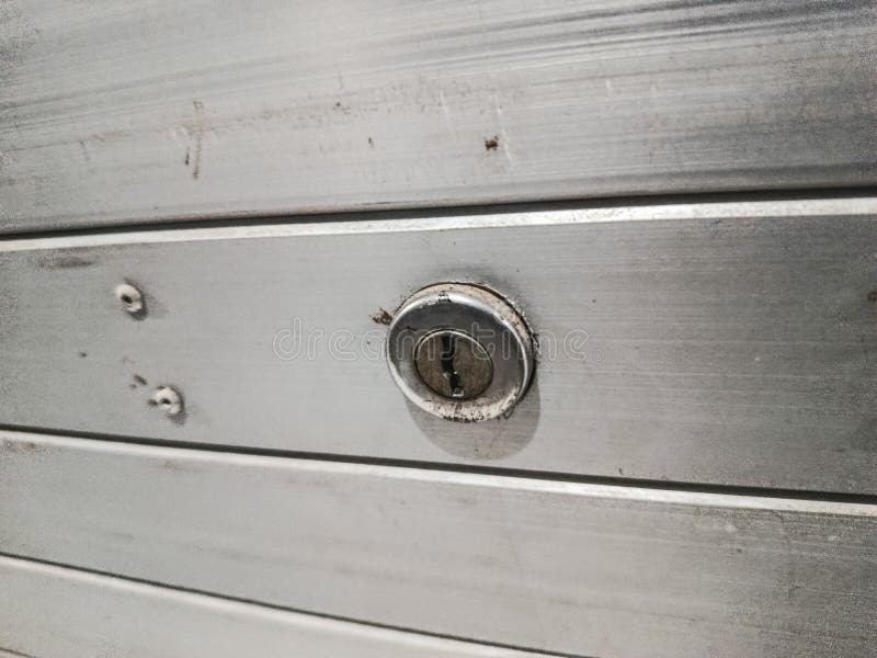 Close-up of Keyhole Lock on Metallic Shutter Door royalty free stock images