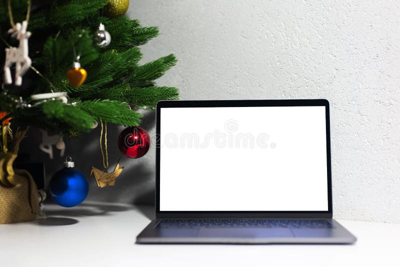 Close-up of laptop with mockup near Christmas tree. royalty free stock images