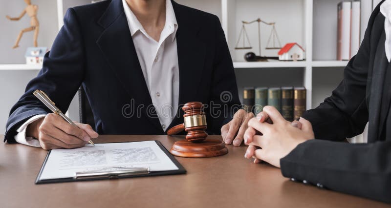 Close-up of lawyer and businesswoman signing legal documents of doing business in lawyer's office room stock photo