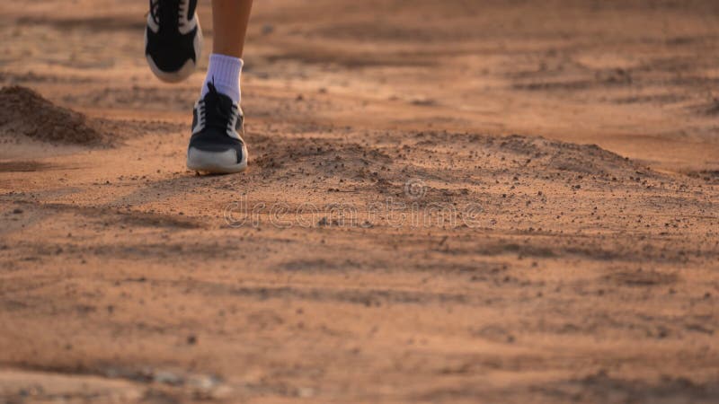 Close up leg of boy running on ground on light of sunset, kids jogging on rural countryside for good heath