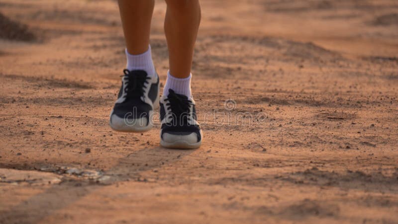 Close up leg of boy running on ground on light of sunset, kids jogging on rural countryside for good heath