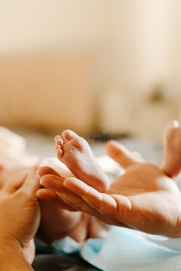 Close up of little baby barefoot feet with mother hand.