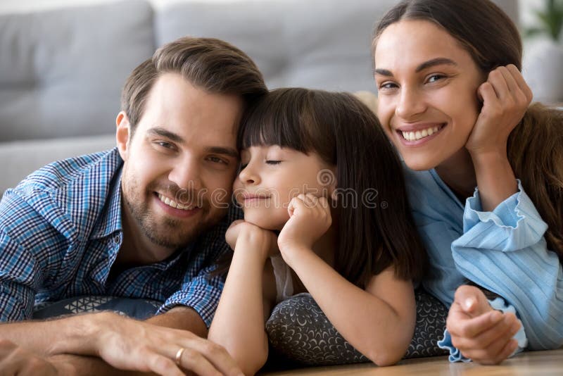 Beautiful diverse family lying on warm floor at home