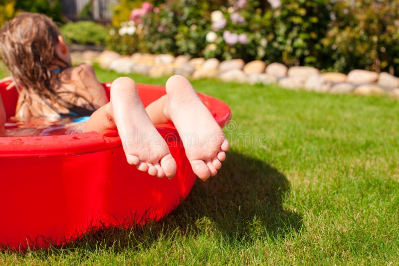 Close-up of a little girl s legs in small red pool