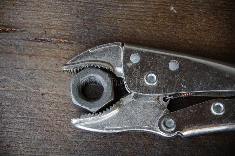 Close up locking pliers on wooden background, Hand tools in work shop royalty free stock image