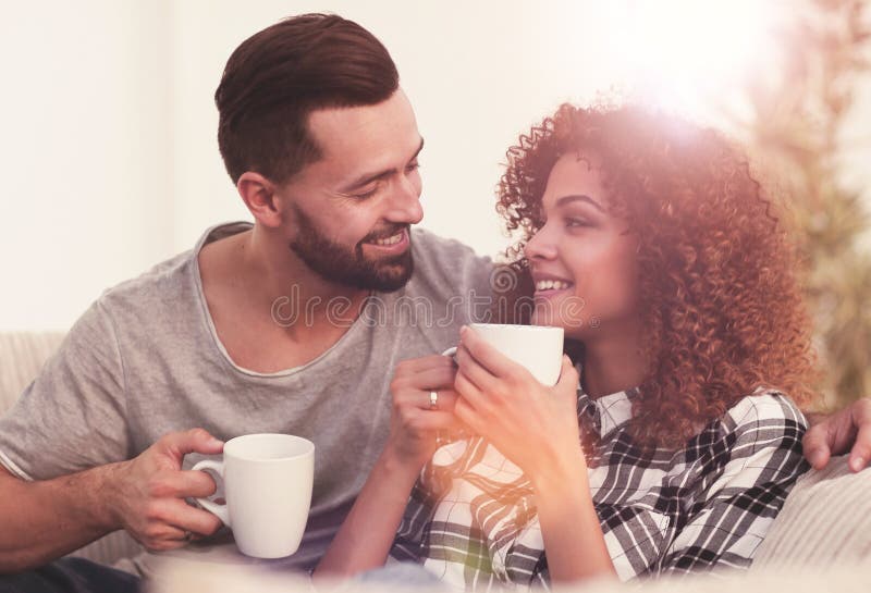 Close-up of a loving couple sitting on a sofa in the living room