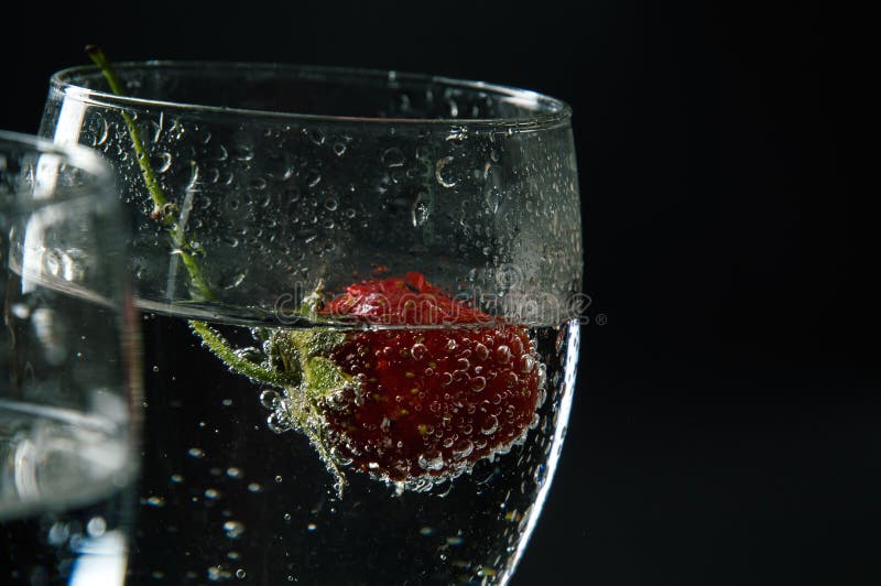 Close Up, Macro. Red Strawberry in a Alcoholic Drink with Bubbles Stock