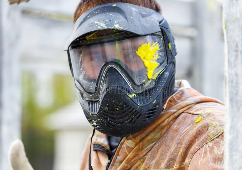 Close-up of male face in paintball mask with big splash