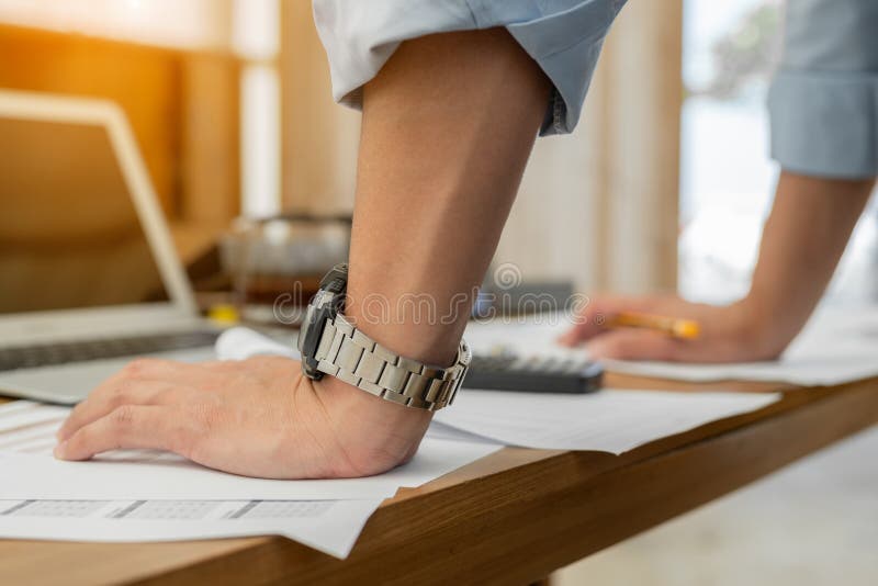 Close up of male hand on table. Businessman standing near table, leaning his hands on table