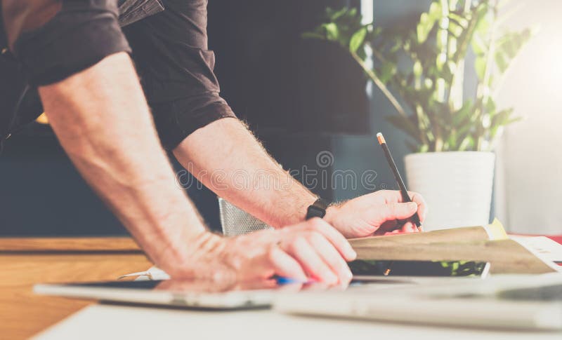 Close-up of male hand on table. Businessman standing near table, leaning his hands on table.