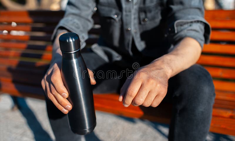 https://thumbs.dreamstime.com/b/close-up-male-hands-holding-steel-reusable-thermo-water-bottle-black-218849974.jpg