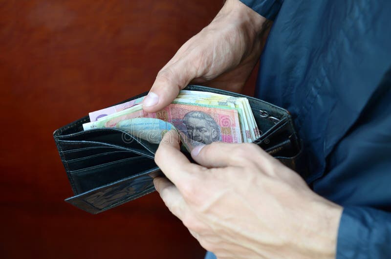 Close up male hands opened the wallet or purse with ukrainian money currency hryvnia