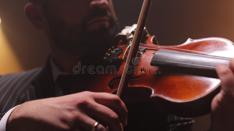 Man playing violin and enjoying creating melody on stage