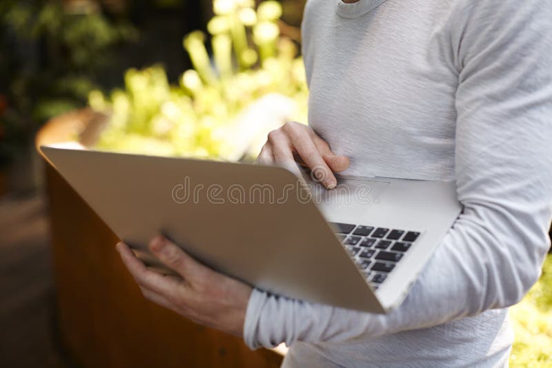 Close-up of man hands, hipster guy working on laptop computer in a garden or park royalty free stock image Close-up of man hands, hipster guy working on laptop computer in a garden or park royalty free stock image