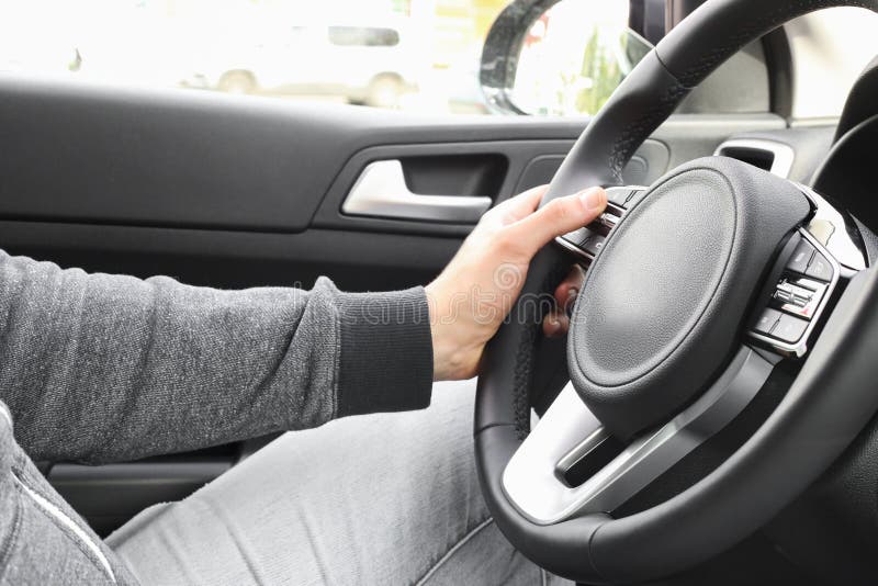 Closeup. a Man Holding the Steering Wheel of a New Car Stock Image