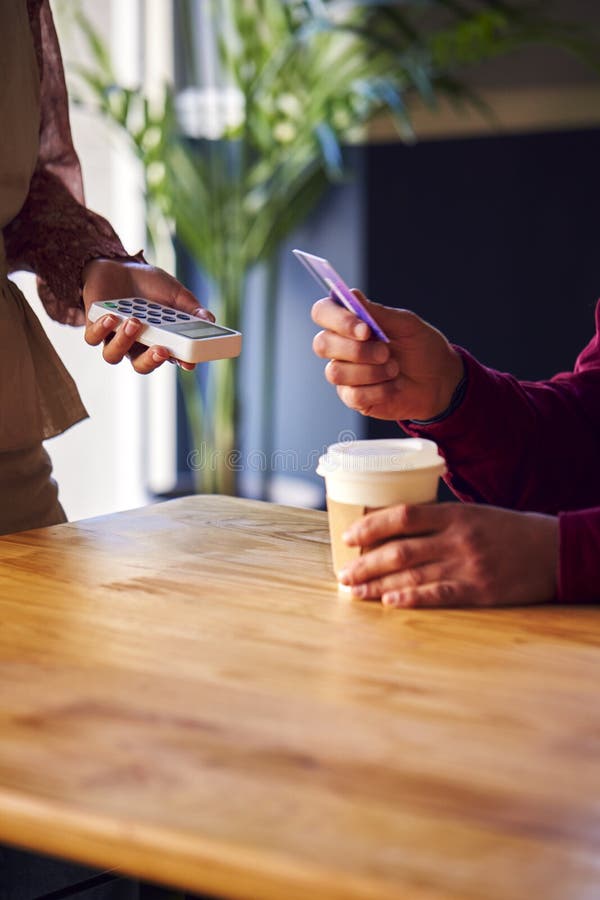 Close Up of Man Paying Female Server in Coffee Shop Using Debit or