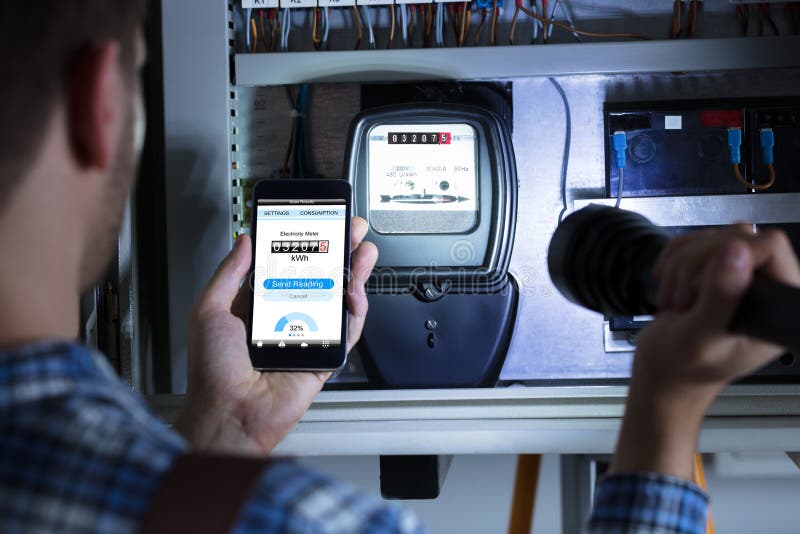 Man`s Hand Holding Mobile Phone Showing Electric Meter Reading