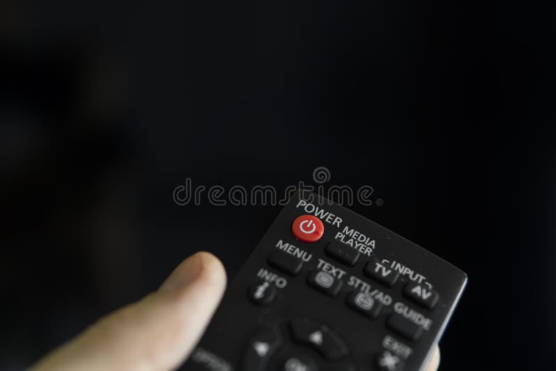 Close up on a man`s hand with the remote control want switch on the TV and presses the button on the remote control. Remote control in hand closeup royalty free stock photo Close up on a man`s hand with the remote control want switch on the TV and presses the button on the remote control. Remote control in hand closeup royalty free stock photo