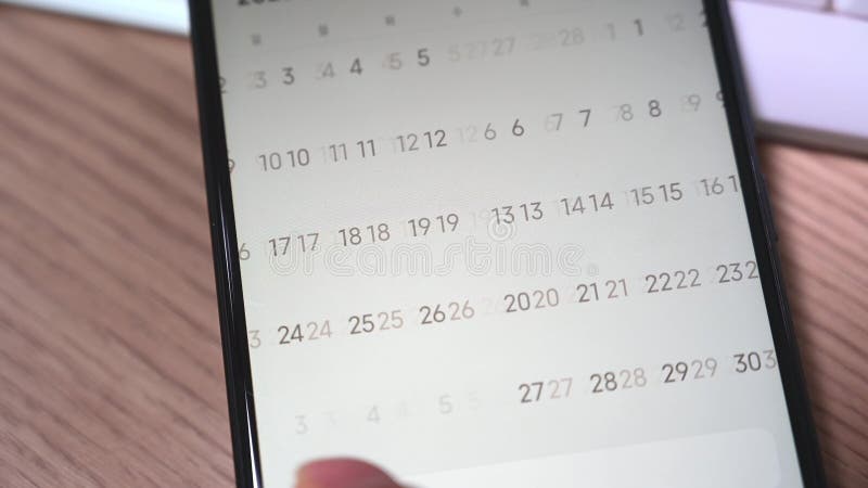 Close-up of a man`s hand using a smartphone calendar application