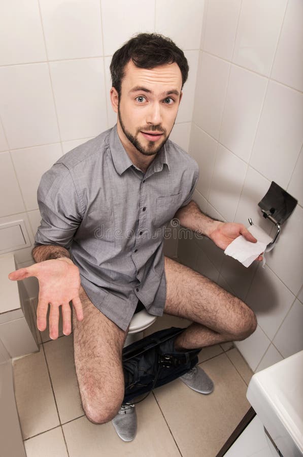 Adult man sitting on bathroom or wc toilet.