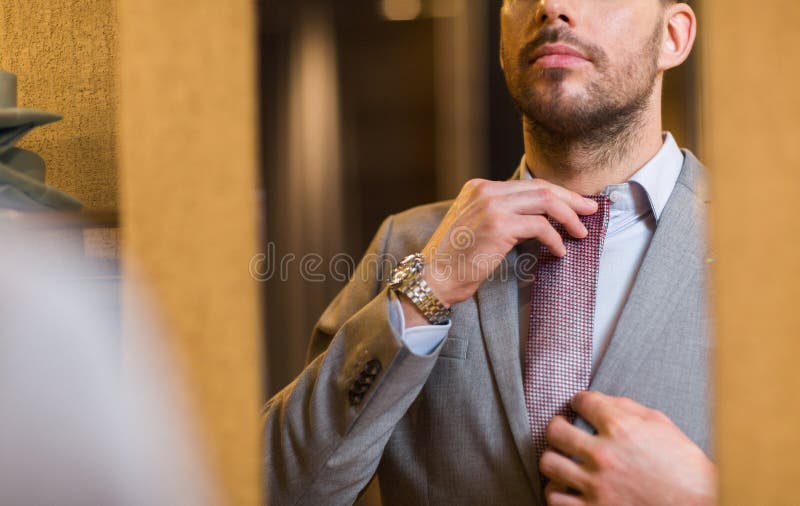 Close up of man trying tie on at mirror