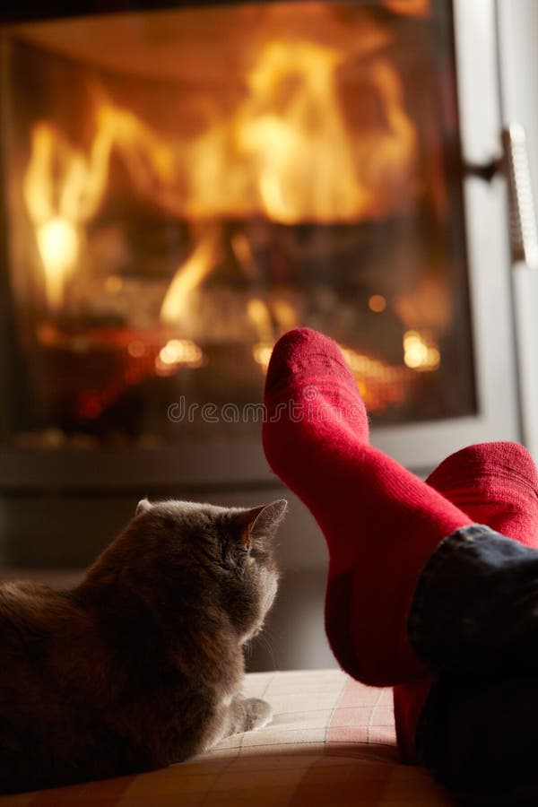 Close Up Of Mans Feet Relaxing by Fire With Cat stock photography Close Up Of Mans Feet Relaxing by Fire With Cat stock photography