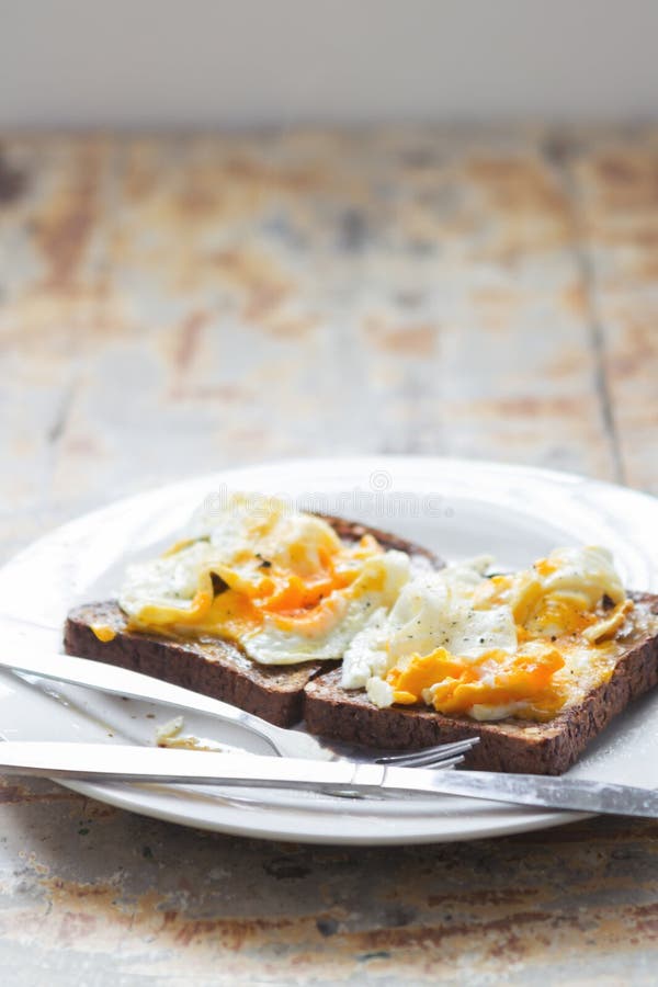 Close up of mashed poached eggs on a rustic kitchen table