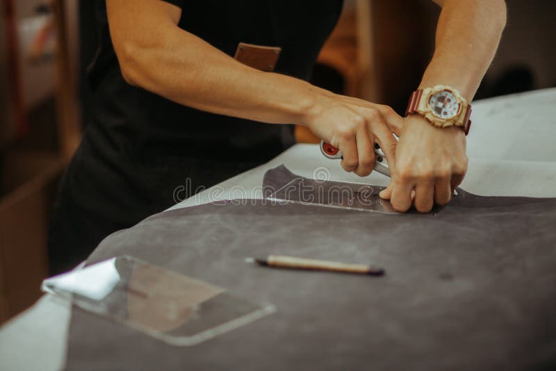 Close Up of a Master Working with Leather Textile at His Using Tools. Handmade Concept