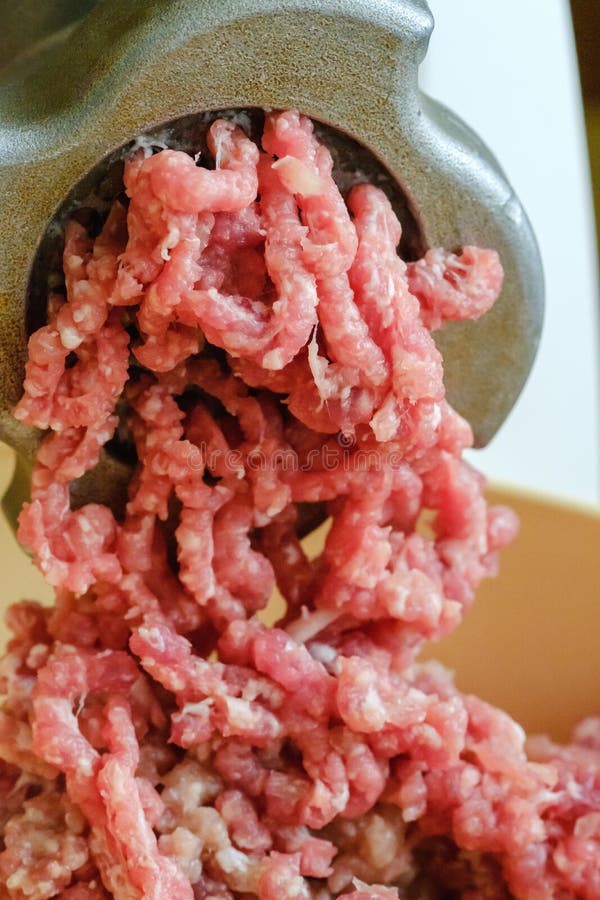 Close Up Meat Grinder or Mincingmachine with Mincemeat in. Showing the