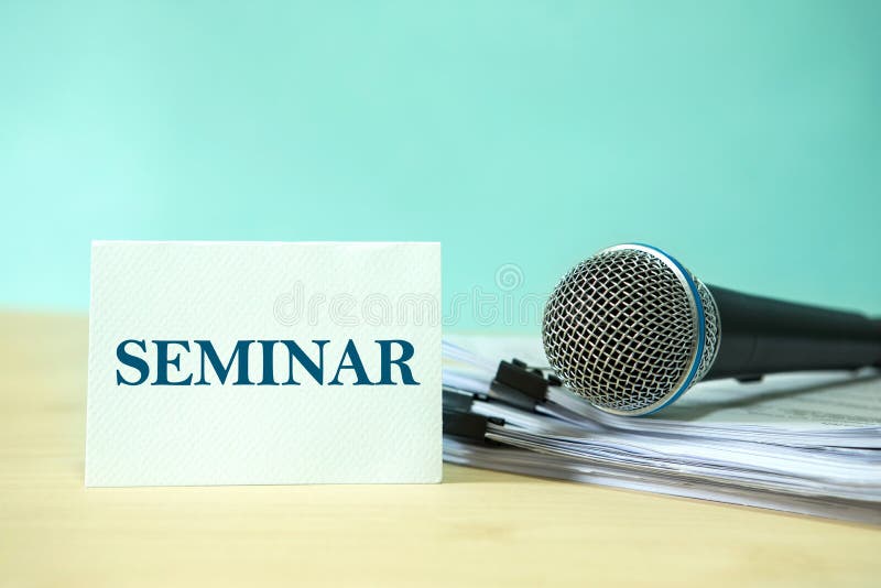 Close up Microphone on paper document with a SEMINAR text, concept of speaker or teacher preparation to speak in seminar class stock image