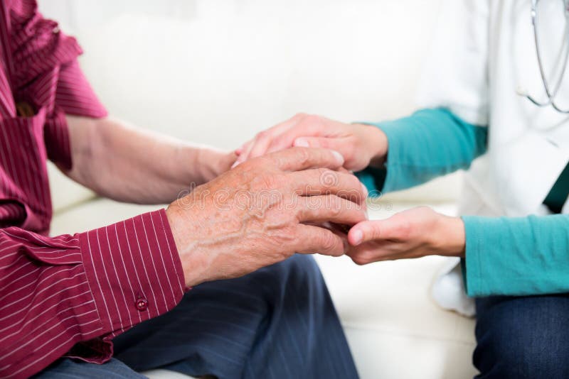 Close-up mid section of a doctor holding patients hands stock images Close-up mid section of a doctor holding patients hands stock images