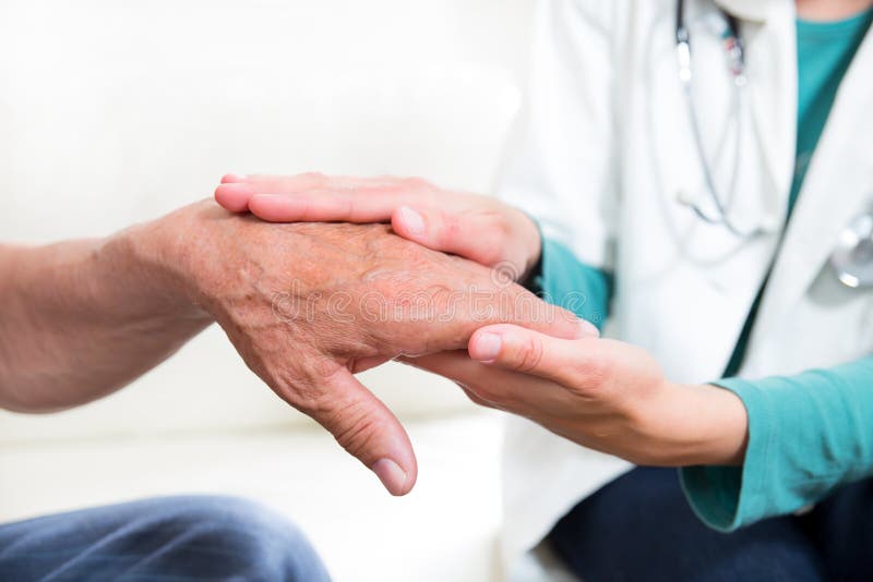 Close-up mid section of a doctor holding patients hands stock image Close-up mid section of a doctor holding patients hands stock image