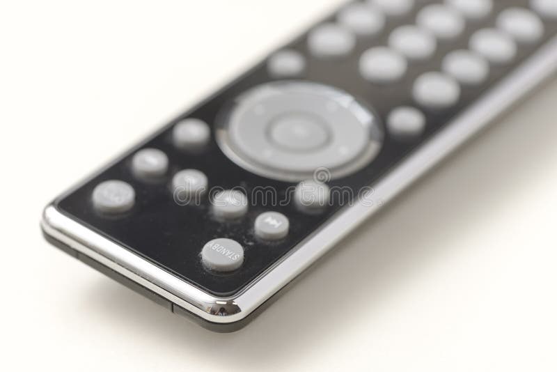 Close up of modern black remote control with grey buttons on a clean neutral background stock images