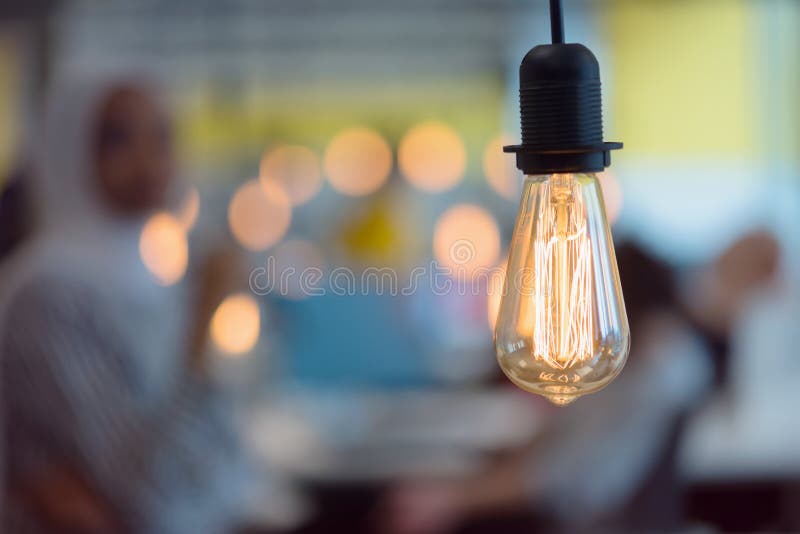 Close up of modern light bulb inside the modern interior of company in blur with employers royalty free stock image Close up of modern light bulb inside the modern interior of company in blur with employers royalty free stock image