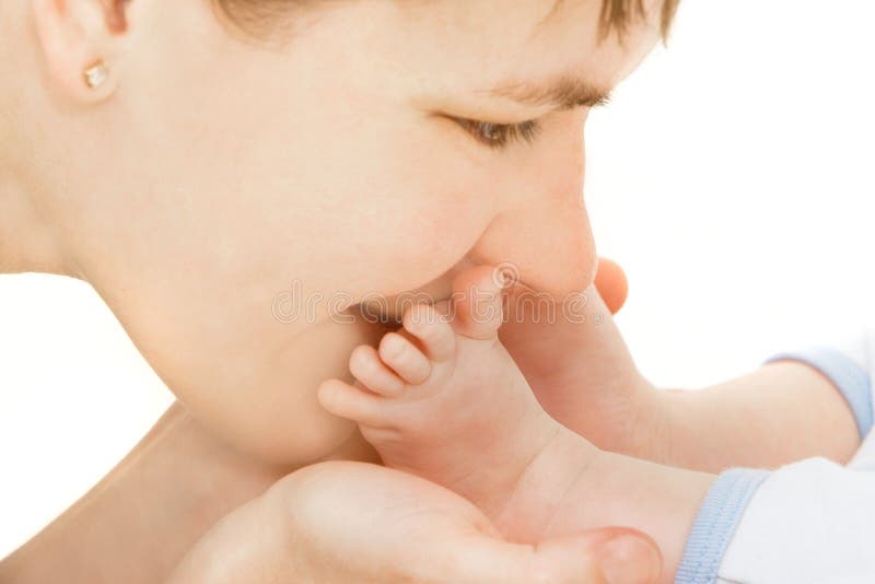 Close up of mother kissing baby s feet