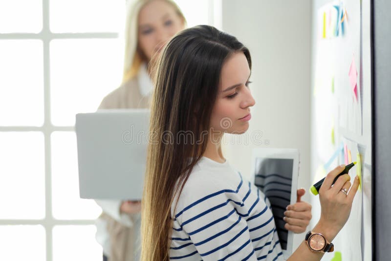 Close up na escrita da mulher de negócio no flipchart no escritório fotos de stock Close up na escrita da mulher de negócio no flipchart no escritório fotos de stock