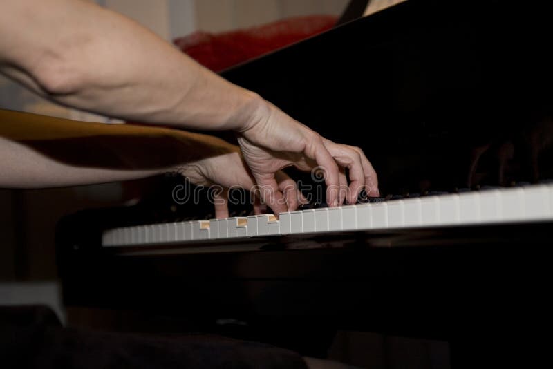 Close-up nas mãos de uma mulher que joga o piano com chaves da música foto de stock royalty free Close-up nas mãos de uma mulher que joga o piano com chaves da música foto de stock royalty free