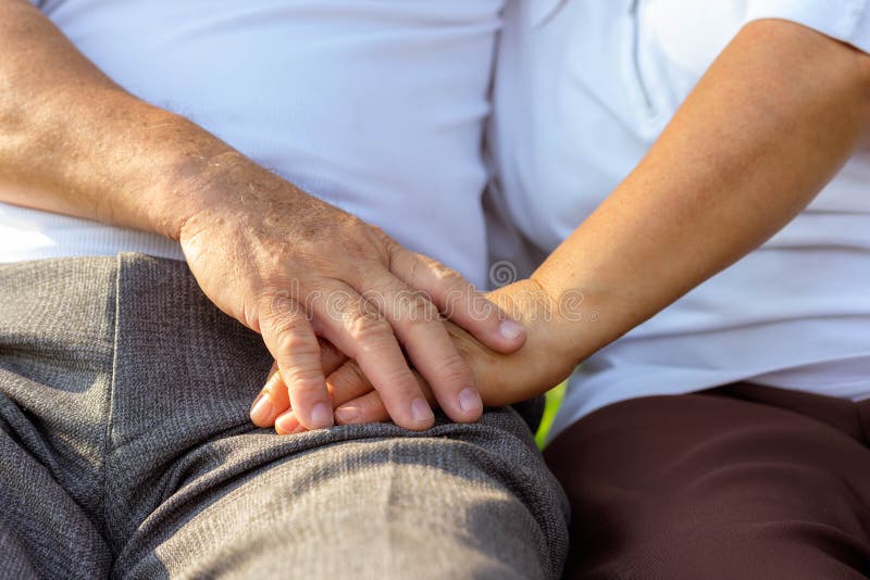 Close up older couple hands. Older husband use hand hold older wifeâ€™s hand together for encouraging his beloved wife.