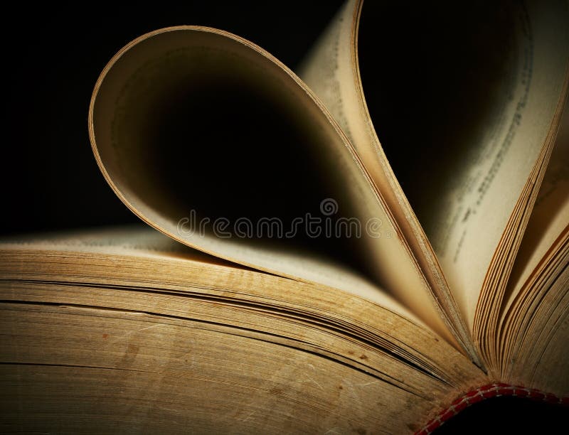 Close-up of opened old book against black background. Shallow DOF. Close-up of opened old book against black background. Shallow DOF.