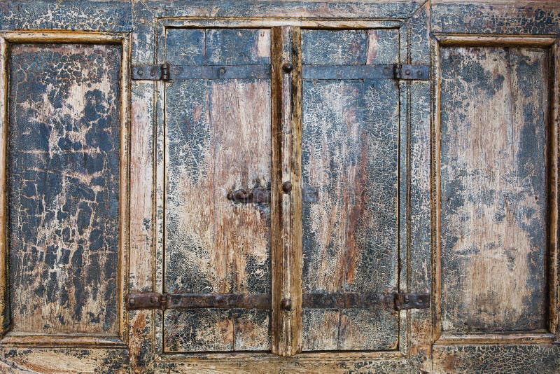 Close up outdoor view of part of ancient closed wooden shutters. Detail of rusty metallic hinges fixed with several screws. Grey p stock photo Close up outdoor view of part of ancient closed wooden shutters. Detail of rusty metallic hinges fixed with several screws. Grey p stock photo