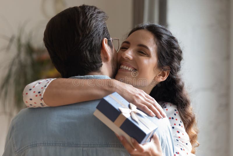 Close up overjoyed young wife hugging husband, thanking for gift. Close up overjoyed wife hugging husband, thanking for romantic present, surprise, happy