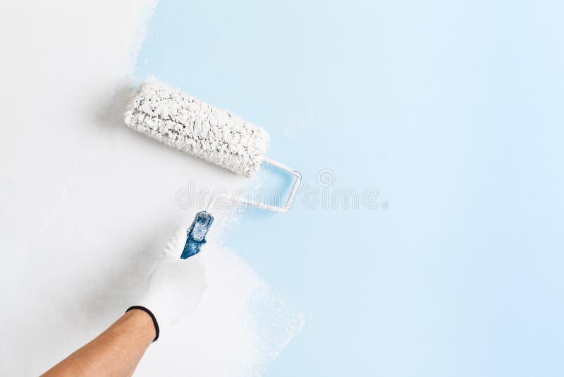 Close up of painter hand painting a wall stock photo