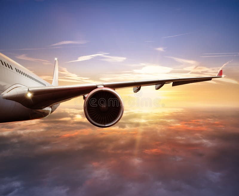 Close-up of passenger airplane flying above clouds