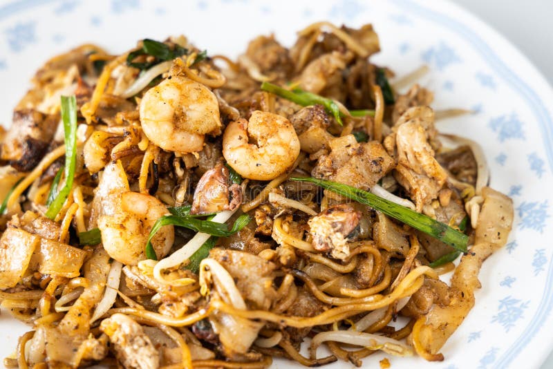 Close-up on Penang char kuey teow is popular fried noodle with coceral, shrimp and eggs in black sauce in Malaysia