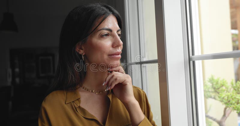 Close up pensive Latina woman looking outside with thoughtful expression stock video